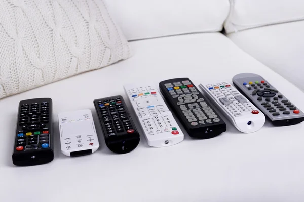 Remote control devices on sofa — Stock Photo, Image