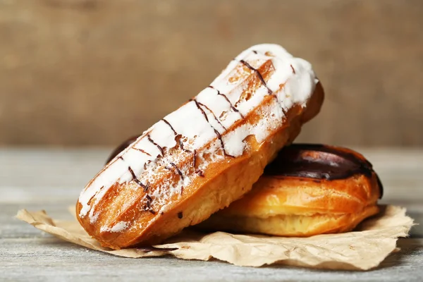 Des éclairs savoureux sur une table en bois, gros plan — Photo