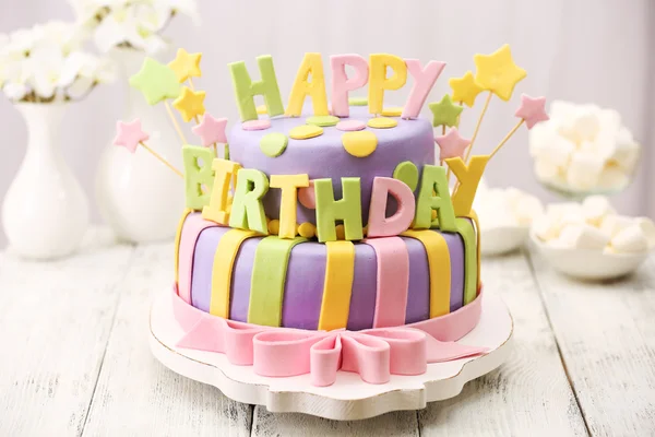 Lezzetli doğum günü pastası ışık arka plan üzerinde masada — Stok fotoğraf