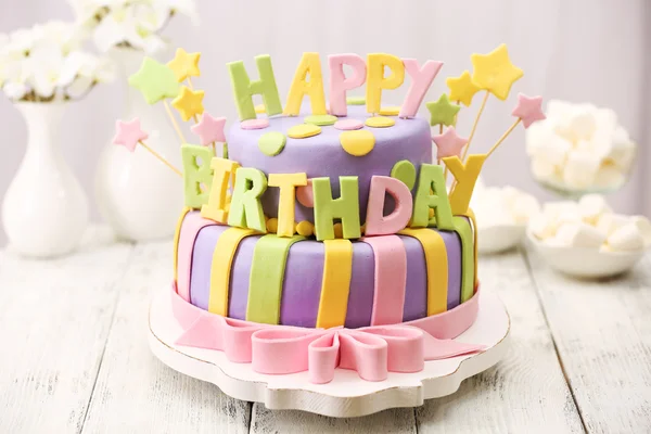 Delicioso bolo de aniversário na mesa no fundo claro — Fotografia de Stock