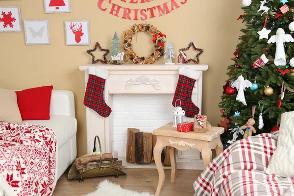 Beautiful Christmas interior with sofa, decorative fireplace and fir tree — Stock Photo, Image