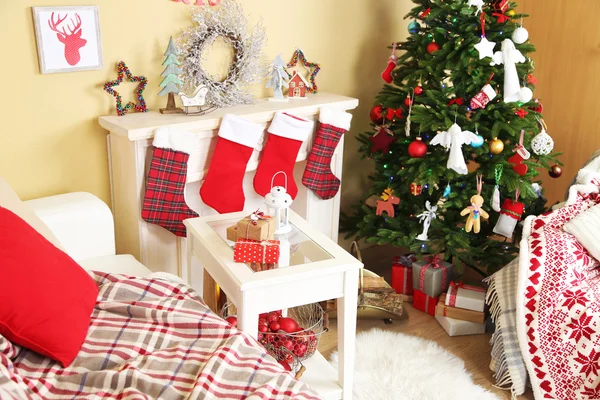 Beautiful Christmas interior with sofa, decorative fireplace and fir tree — Stock Photo, Image