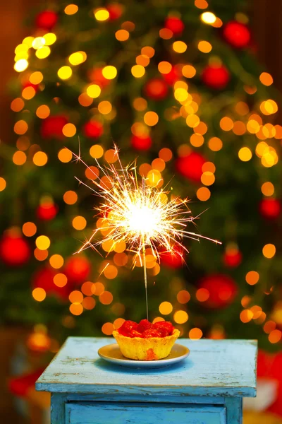 Tasty cake with sparkler on table, on shiny background — Stock Photo, Image