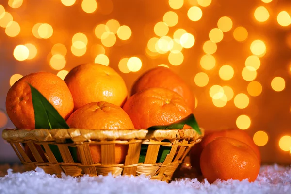 Mandarinas frescas maduras sobre nieve, sobre fondo de luces — Foto de Stock