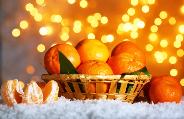 Mandarinas maduras frescas na neve, no fundo das luzes — Fotografia de Stock