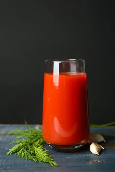Стакан вкусного томатного сока и свежих помидоров на столе, на сером фоне — стоковое фото