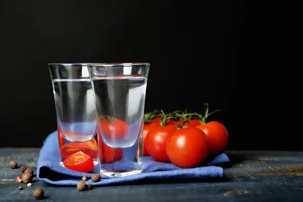 Glas ouzo och tomater på träbord, på grå bakgrund — Stockfoto