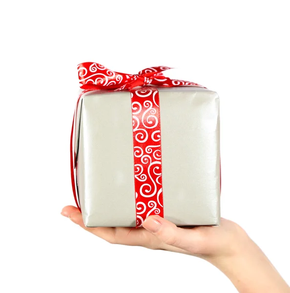 Female hand holding present box with ribbon on light background — Stock Photo, Image