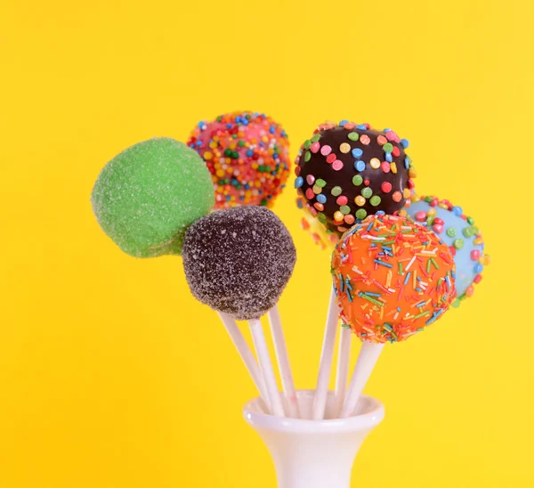 Gâteau sucré apparaît dans un vase sur fond jaune — Photo