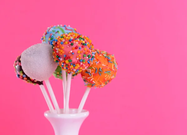 Sweet cake pops in vase on pink background — Stock Photo, Image