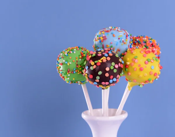 Süße Cake Pops in der Vase auf blauem Hintergrund — Stockfoto