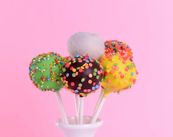 Sweet cake pops in vase on pink background — Stock Photo, Image