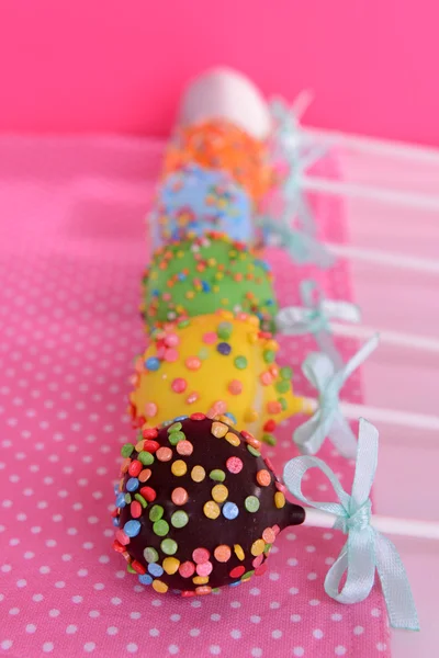 Söta cake pops på tabellen på rosa bakgrund — Stockfoto