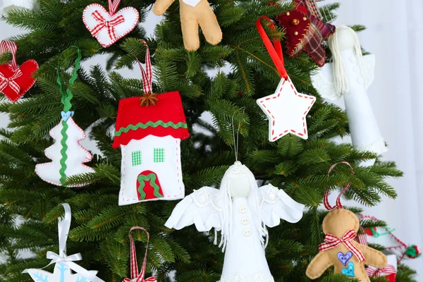 Decorações artesanais de Natal na árvore de Natal no fundo claro — Fotografia de Stock