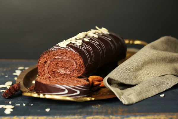 Delicious roll cake on wooden table, on dark background — Stock Photo, Image