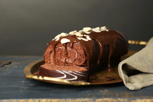 Delicious roll cake on wooden table, on dark background — Stock Photo, Image