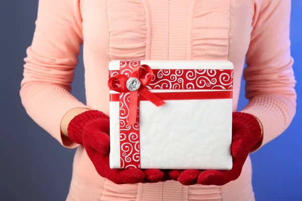 Gift box in female hand on color background — Stock Photo, Image