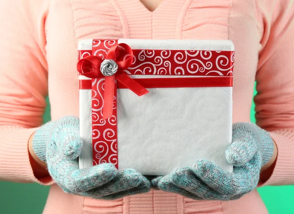 Gift box in female hand on color background — Stock Photo, Image