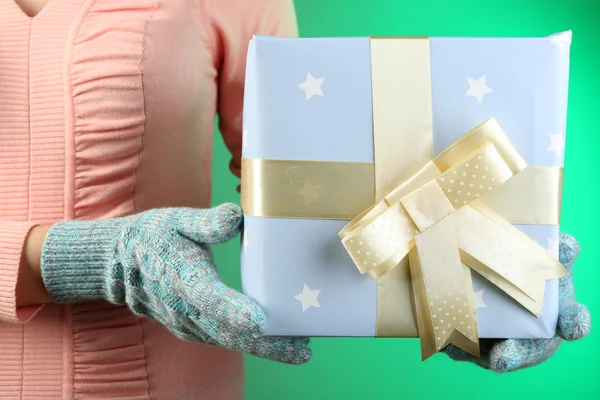 Scatola regalo in mano femminile su sfondo a colori — Foto Stock