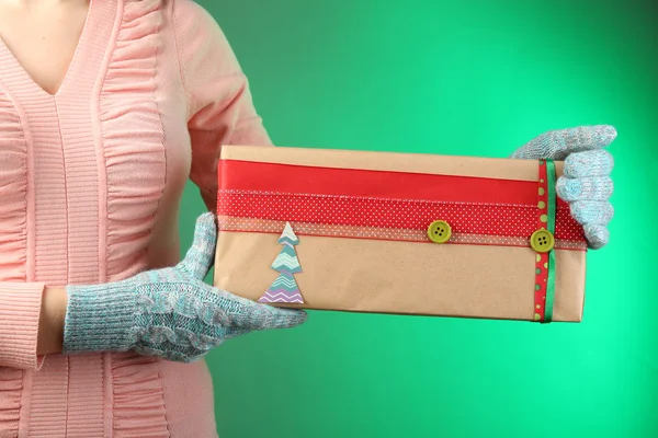 Scatola regalo in mano femminile su sfondo a colori — Foto Stock