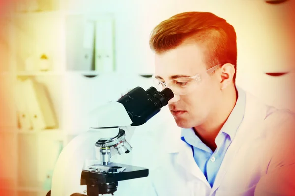 Giovane ricercatore di sesso maschile che svolge ricerche scientifiche in laboratorio — Foto Stock
