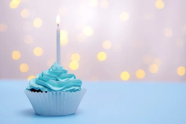 Delicioso cupcake de aniversário na mesa no fundo claro — Fotografia de Stock