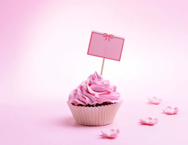 Delicious cupcake with inscription on table on pink background — Stock Photo, Image