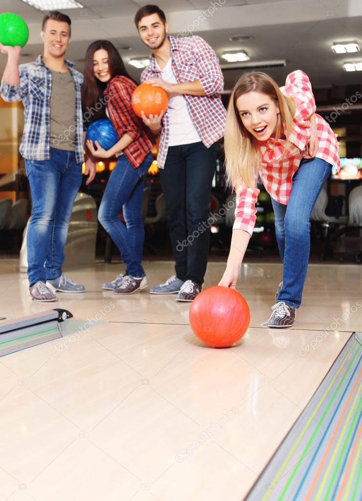 Young friends playing in bowling alley