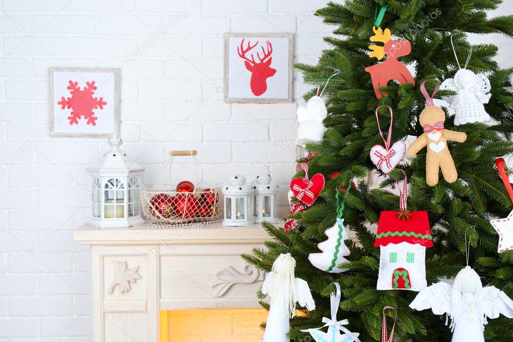 Christmas handmade decorations on Christmas tree  on light home interior background