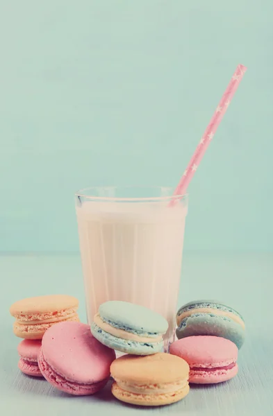 Assortment of gentle colorful macaroons and glass of milk on color background — Stock Photo, Image