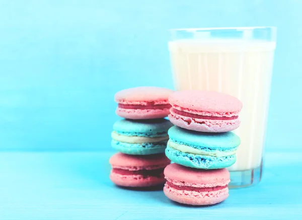 Assortment of gentle colorful macaroons and glass of milk on color background — Stock Photo, Image