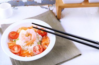 Haşlanmış pirinç ve karides, somon ve kase, ahşap arka plan domates