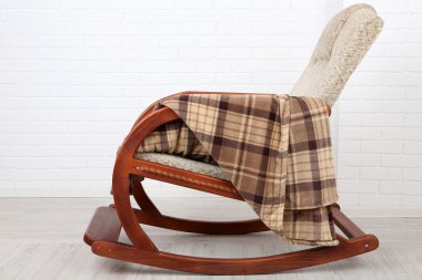 Ekose tuğla duvar arka plan yakınındaki ahşap zemin üzerinde sallanan sandalye kaplı