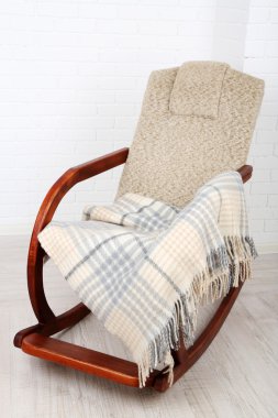 Ekose tuğla duvar arka plan yakınındaki ahşap zemin üzerinde sallanan sandalye kaplı