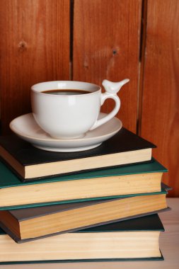 Yığın masa üstü ve ahşap arka plan üzerinde Kupası ile kitap