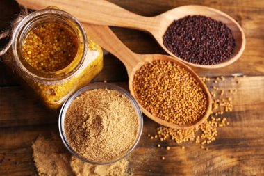 Hardal tohumu, toz ve Cam Kavanoz, kase ve tahta kaşıklar ahşap zemin üzerine sos