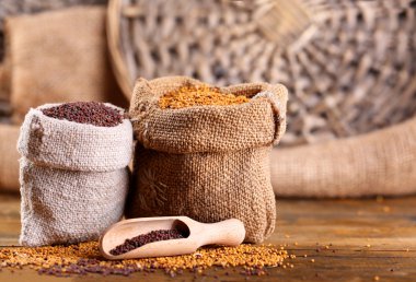 Ahşap arka plan üzerinde torbalarda hardal tohumu