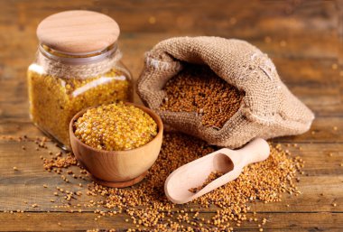 Çanta ve kavanoz ve kase ahşap arka plan üzerinde Dion hardal hardal tohumu