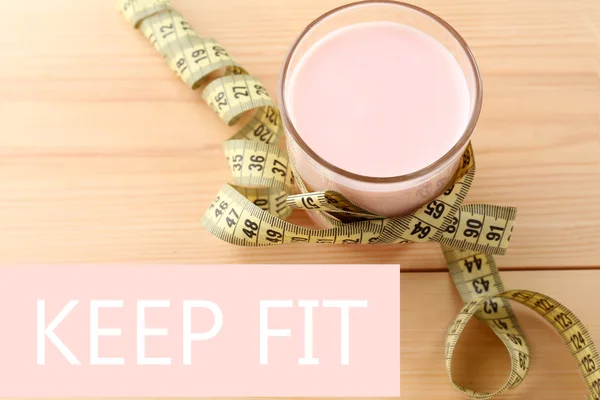 Vidro de iogurte com fita métrica em fundo de madeira, conceito de dieta — Fotografia de Stock