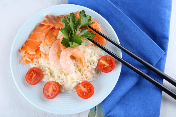 Gekochter Reis und Garnelen, Lachs auf Teller, auf Holzgrund — Stockfoto
