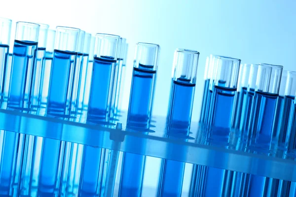 Blue water in a transparent test-tube on light background — Stock Photo, Image