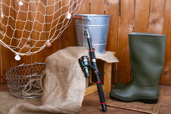 Fishing equipment on wooden wall background, indoors — Stock Photo, Image