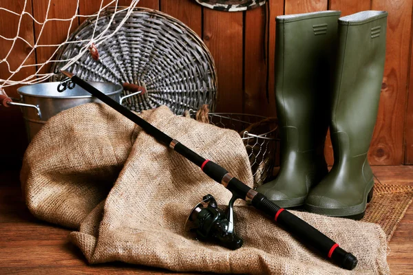Fishing equipment on wooden wall background, indoors — Stock Photo, Image