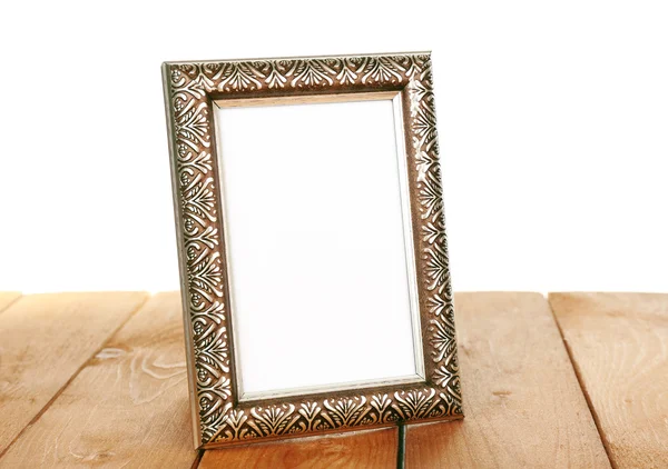 Photo frame on wooden table isolated on white — Stock Photo, Image