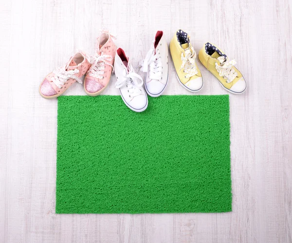 Green carpet on floor and converse close-up — Stock Photo, Image