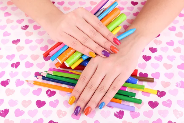 Multicolor female manicure with markers and pencils on bright background — Stock Photo, Image