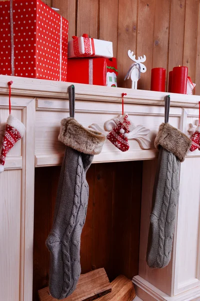 Chimenea con regalos y decoración de Navidad sobre fondo de pared de madera — Foto de Stock