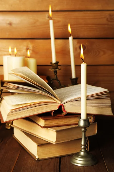 Ретро подсвечники со свечами и книгами, на деревянном фоне — стоковое фото