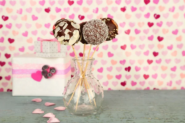 Tasty cake pops and gifts on color background — Stock Photo, Image