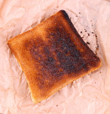 Ahşap masa arka plan ve kağıt üzerinde yanmış tost ekmeği
